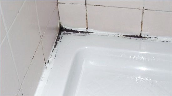 Black mould along the silicone seal of a shower tray